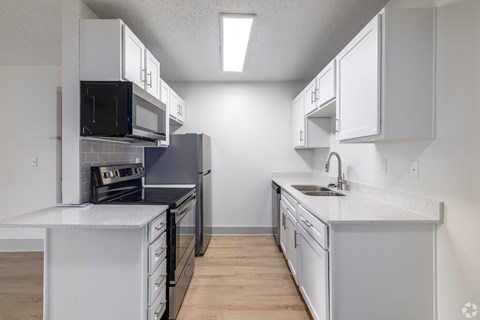 A kitchen with white cabinets and a black stove top oven.