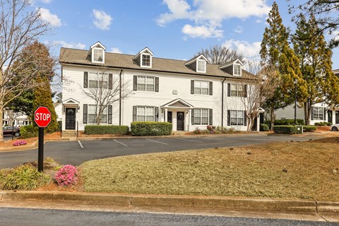 A stop sign is in front of a white building.
