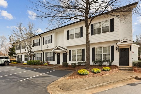 A white two-story building with black shutters and a black door.