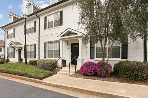 A white house with a black front door and windows.