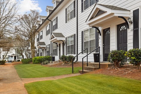 A white two story house with a black door and windows.
