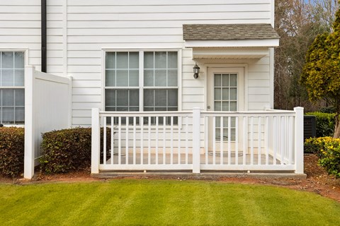 A white house with a white fence and a small window.