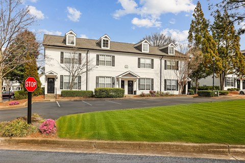 A stop sign is in front of a white building.