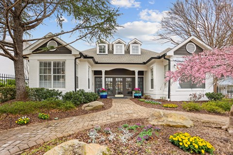 A white house with a grey roof and a grey front door.