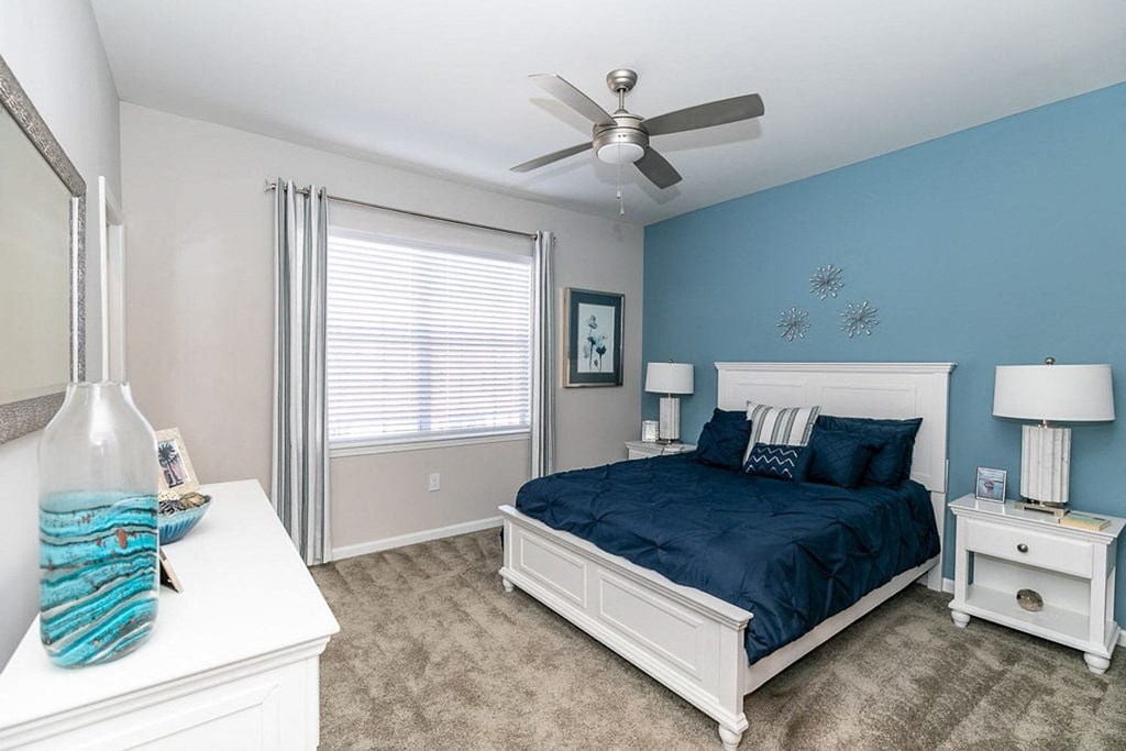 a bedroom with a bed and a ceiling fan
