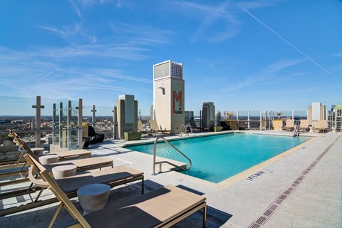 a swimming pool on the rooftop of a building with a city in the background