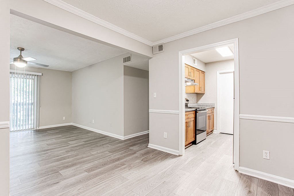 an empty living room and kitchen with wood flooring