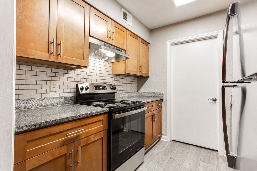 a kitchen with wood cabinets and black and white appliances