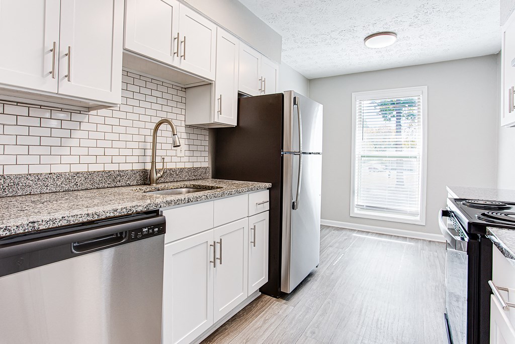 a kitchen with white cabinets and a stainless steel refrigerator