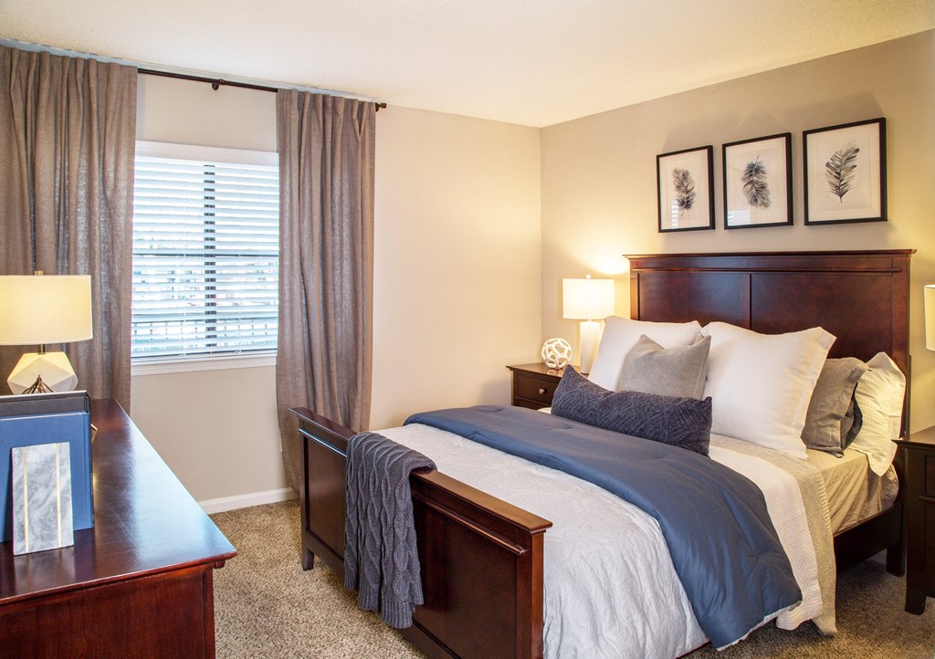 a bedroom with a bed and a dresser and a window