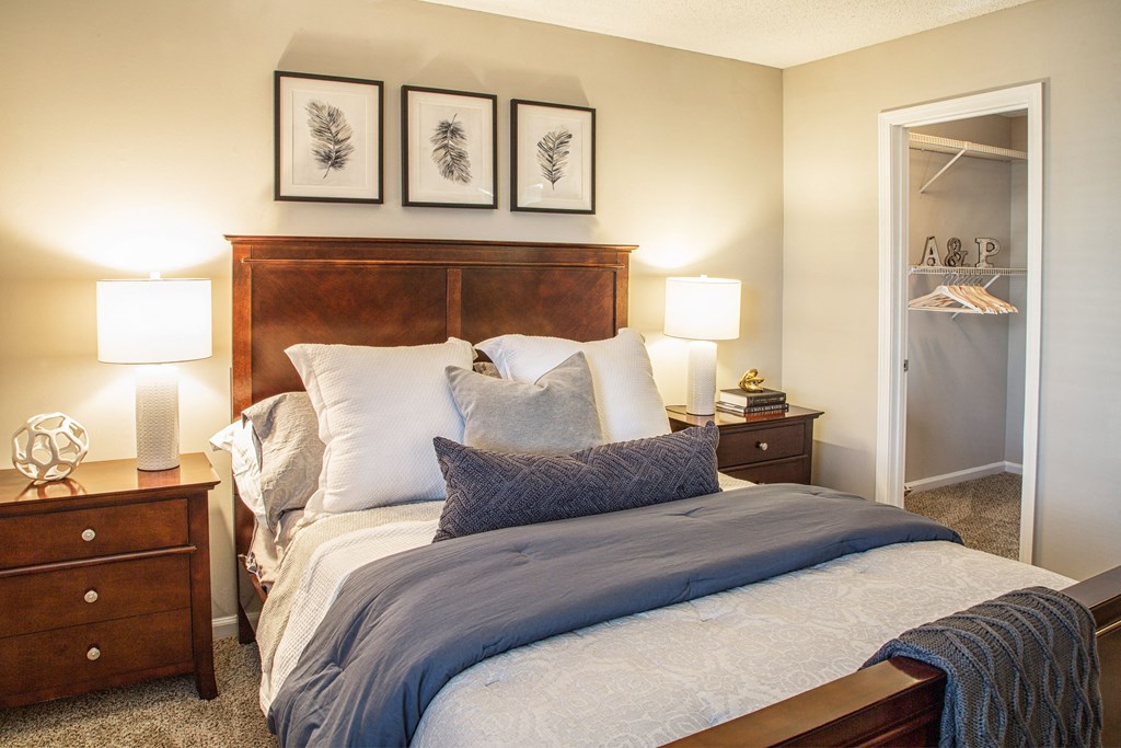 a bedroom with a bed and two nightstands and a closet