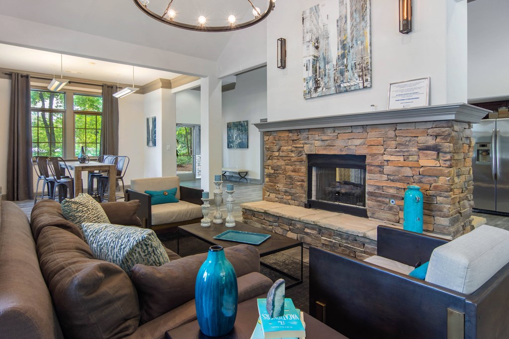 the living room has a large stone fireplace and leather furniture