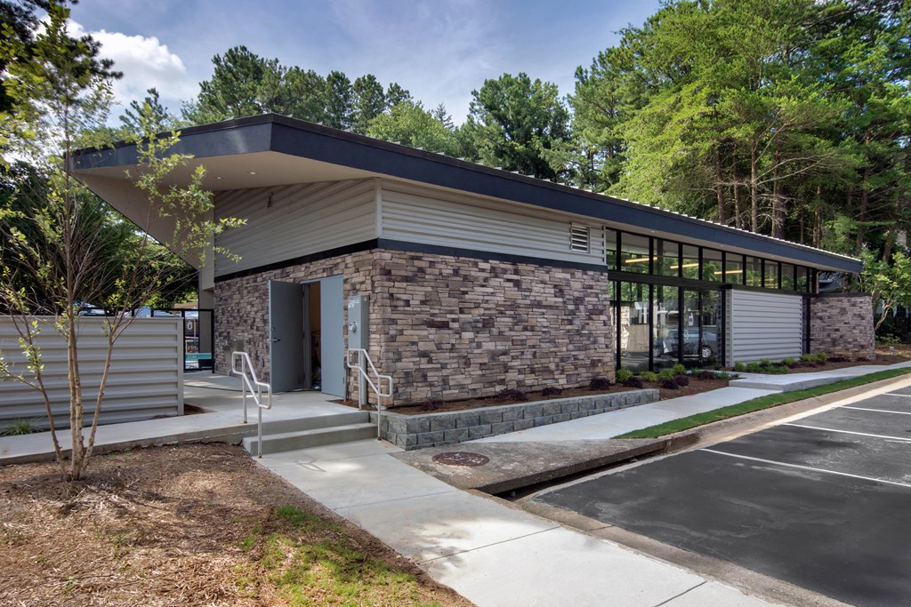 a modern building with a stone facade and a driveway