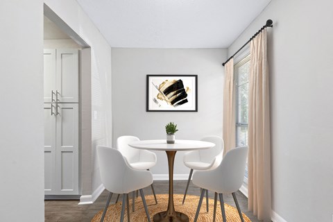 a dining room with a table and chairs and a painting on the wall