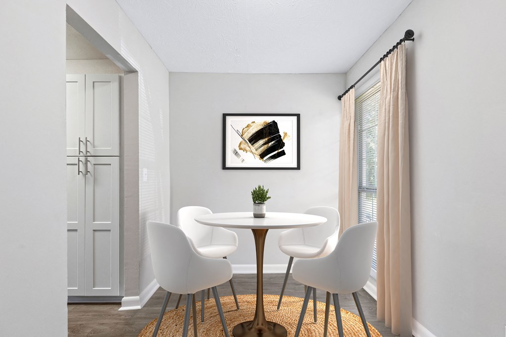 a dining room with a table and chairs and a painting on the wall