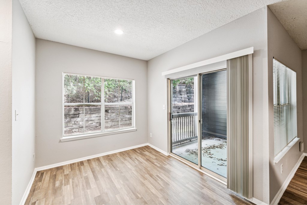 A room with a sliding glass door leading to a balcony.