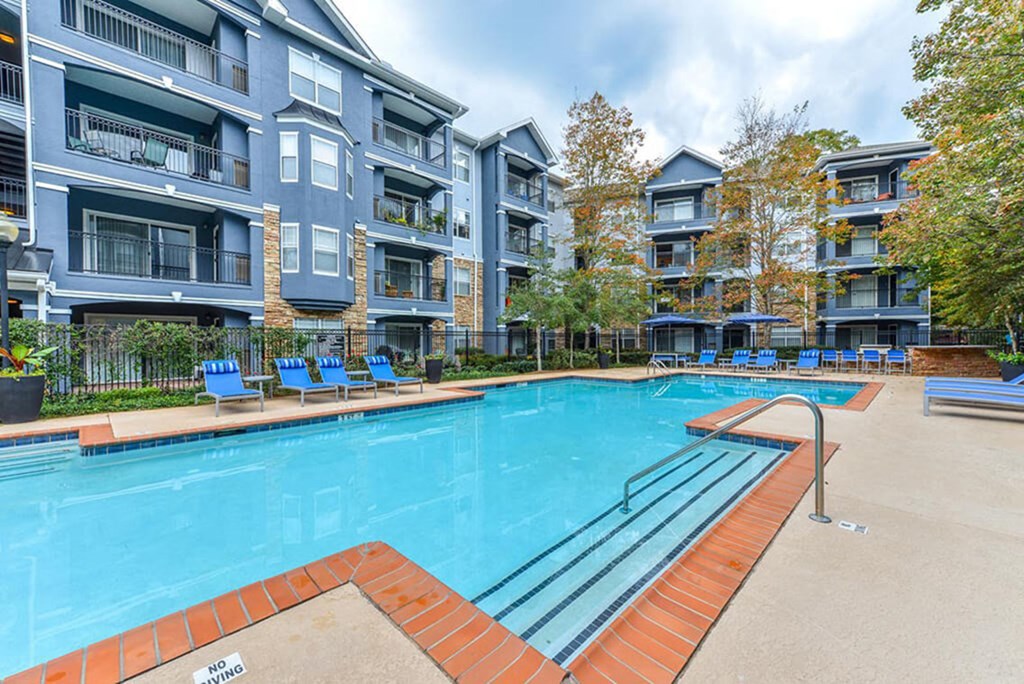 A swimming pool surrounded by apartment buildings.