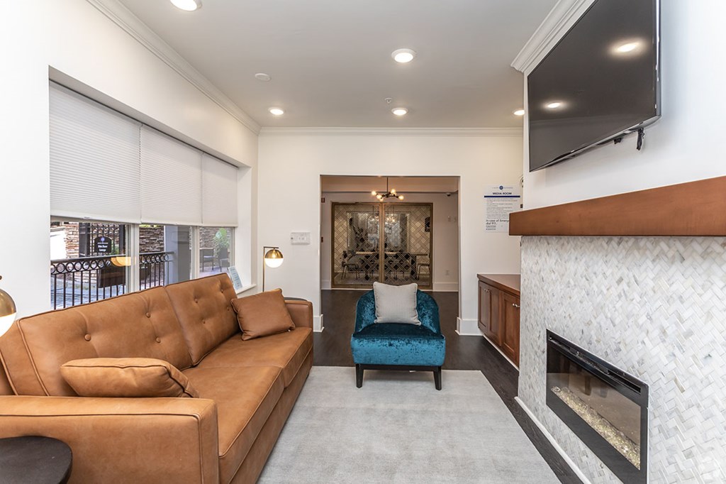 A living room with a brown couch and a fireplace.