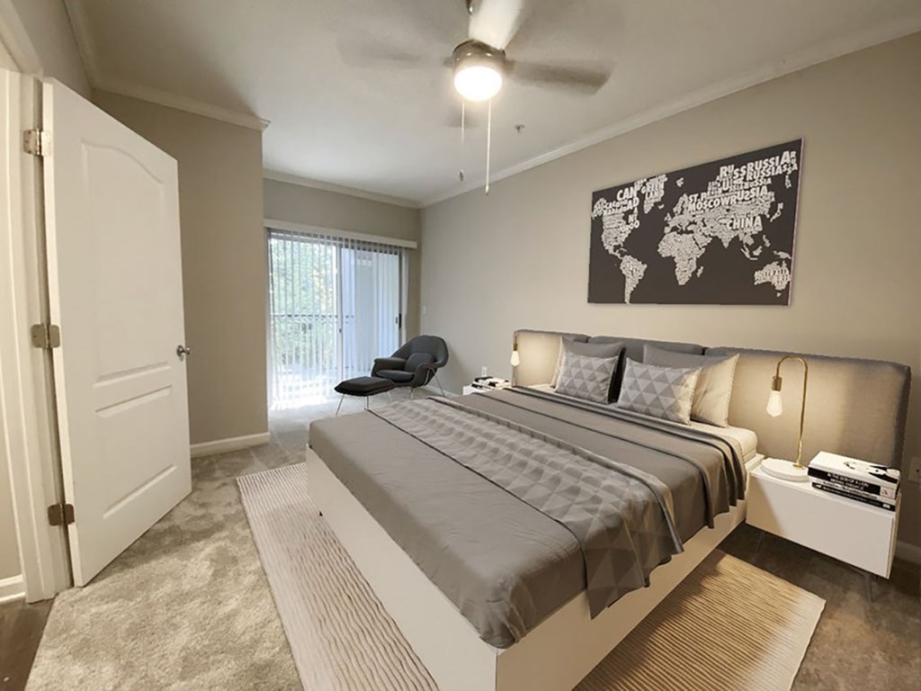 A bedroom with a large bed and a world map on the wall.