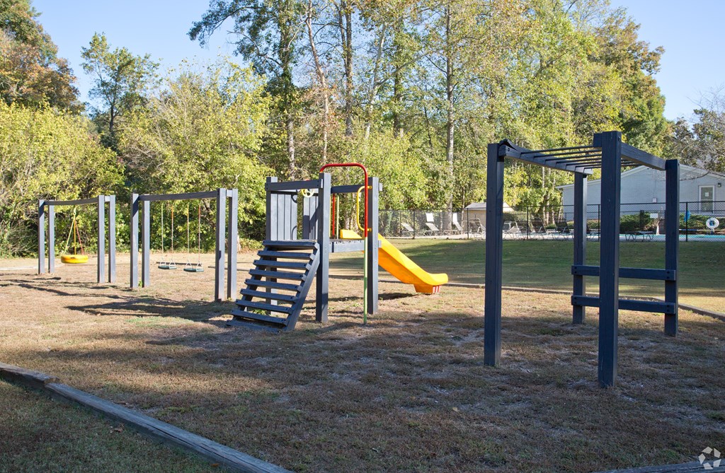 A playground with a slide, monkey bars, and a swing set.