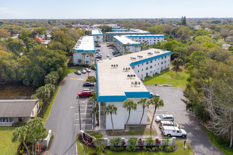 An aerial view of apartment buildings and parking space at Ashford Bayside apartments in Kenneth City, FL