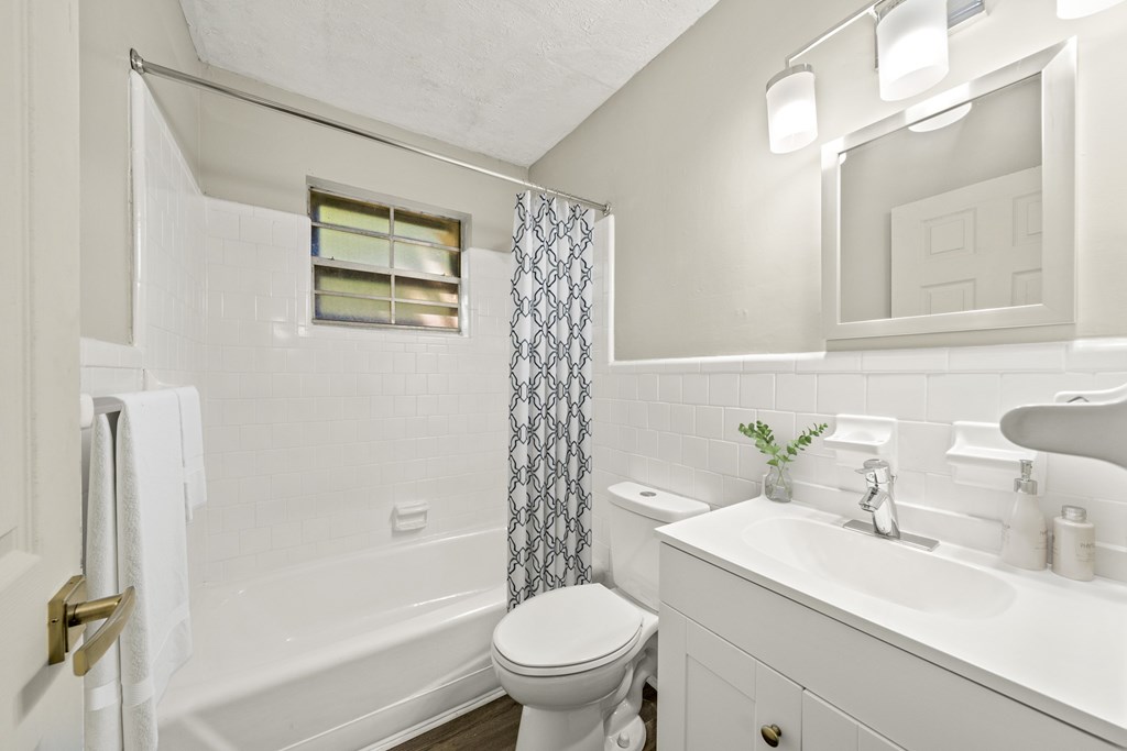 A white bathroom with a toilet, sink, and bathtub.