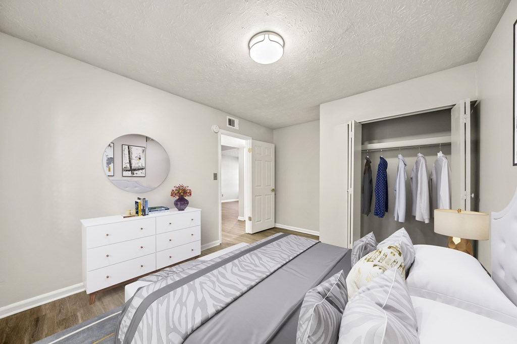 A bedroom with a bed, dresser, and mirror.