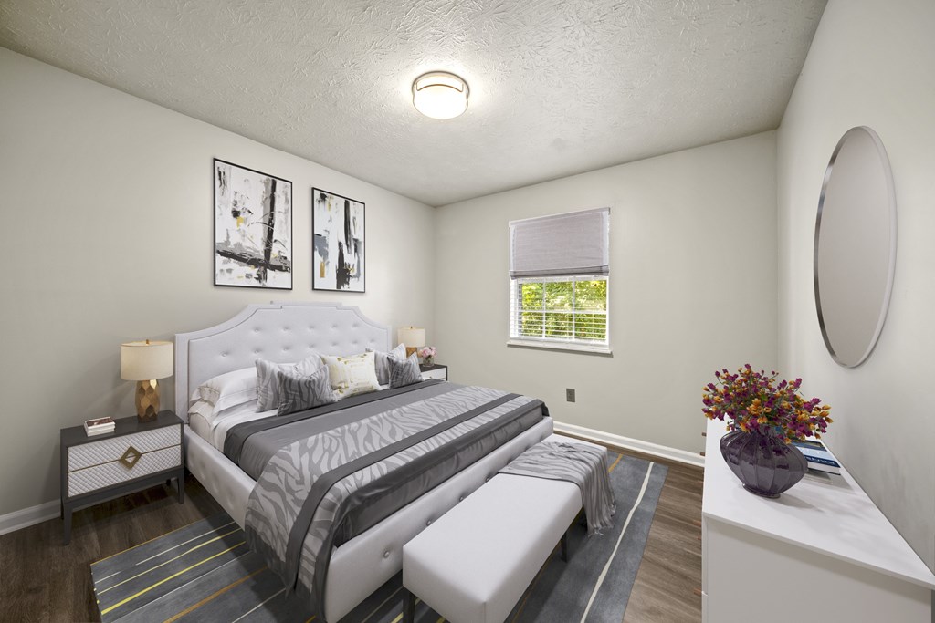 A bedroom with a large bed and a nightstand with a lamp.