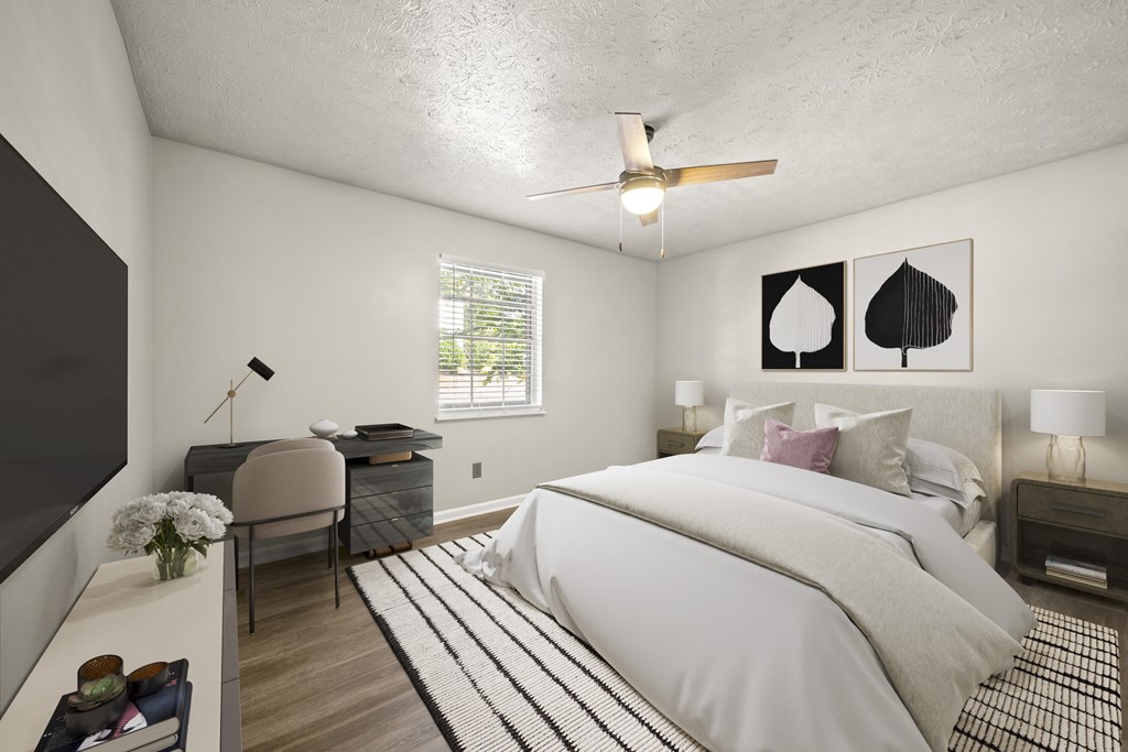 A bedroom with a large bed and a ceiling fan.