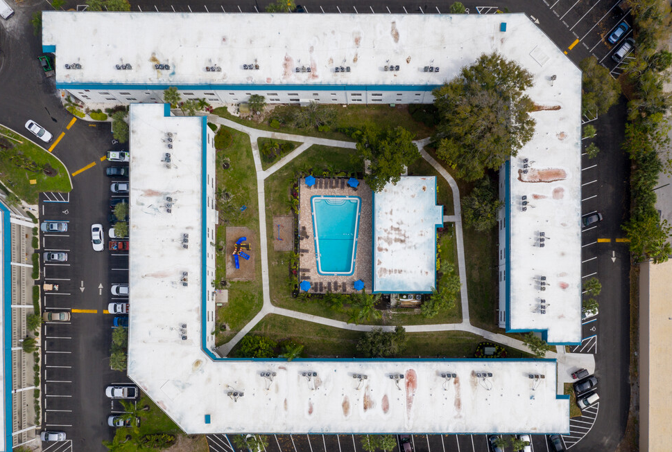 Aerial view of entire apartment community, including parking space, and swimming pool