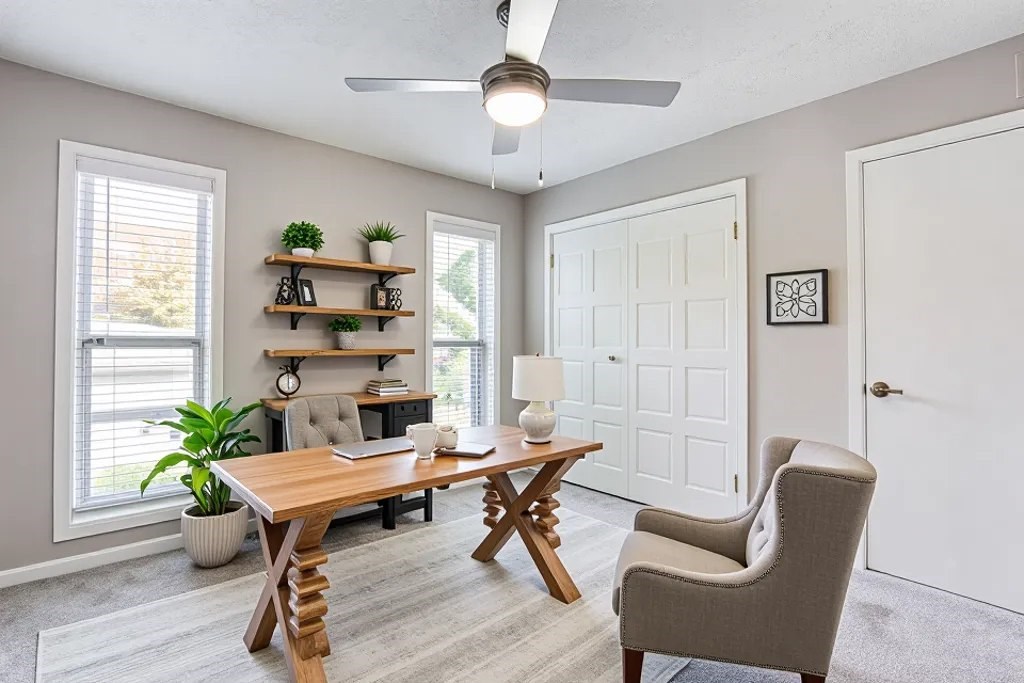 A room with a table, chairs, and a ceiling fan.