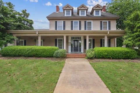 A large house with a porch and a covered walkway.