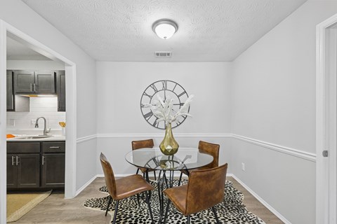 A dining room with a table set for four.