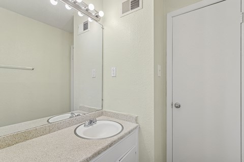 A bathroom with a sink and mirror.