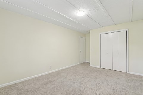 A room with a white ceiling and carpeted floor.