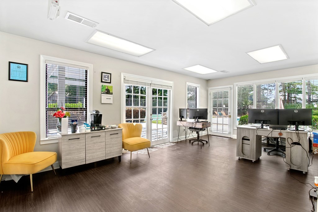 A room with a yellow chair and a desk with a computer.