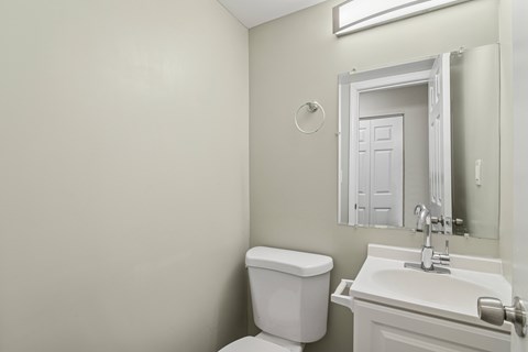 A white toilet and sink in a bathroom.
