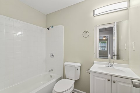 A white toilet sits next to a white sink in a bathroom.