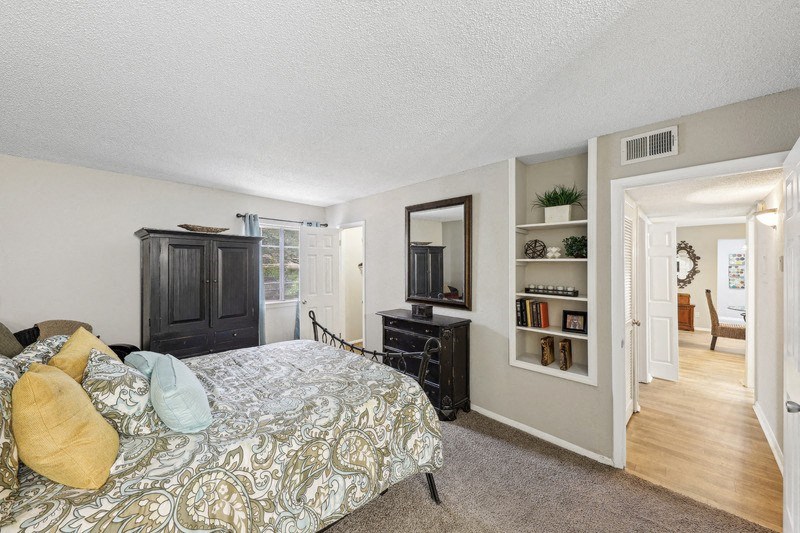a bedroom with a bed and a dresser and a window