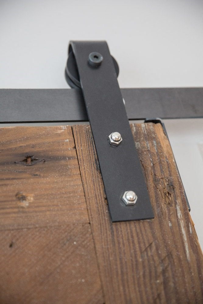 a black strap with two rivets on a piece of wood