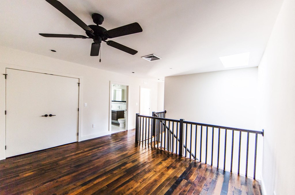 a living room with hardwood floors and a ceiling fan