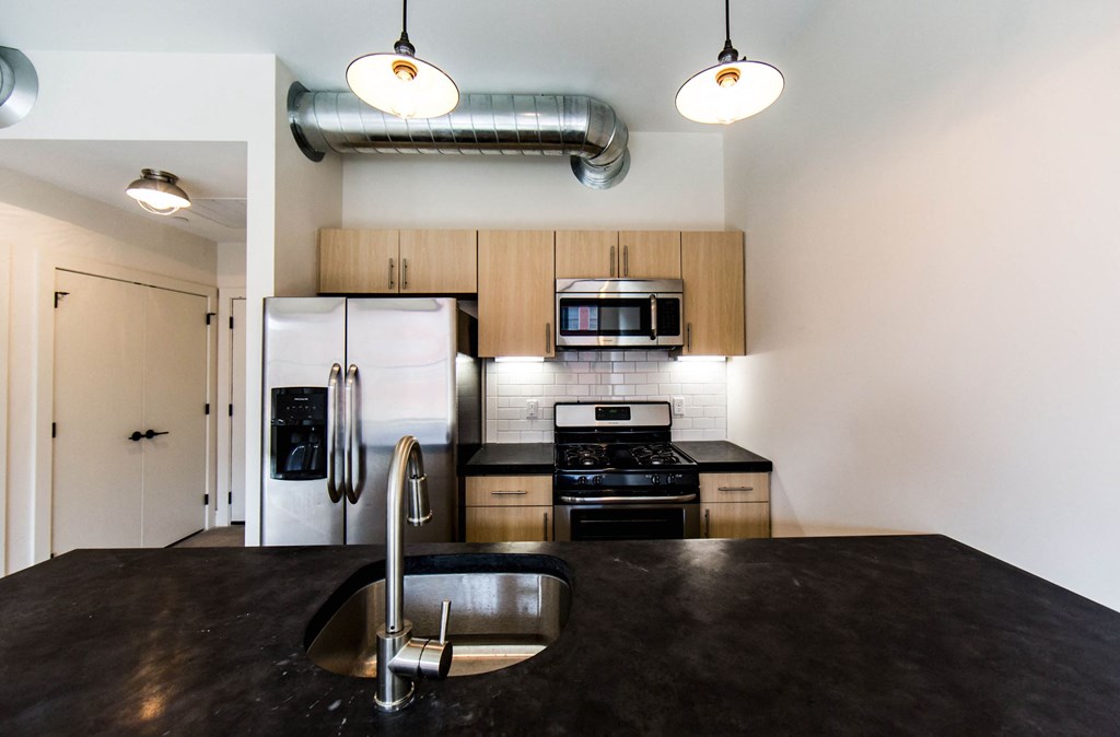 a kitchen with stainless steel appliances and black counter tops