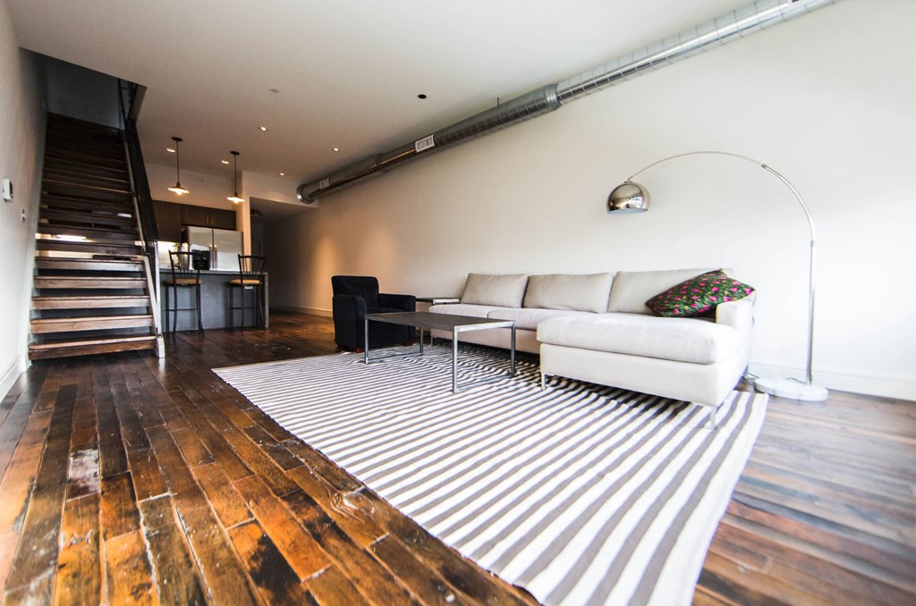 a living room with a white couch and a striped rug