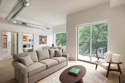 A living room with a grey couch and a wooden chair.