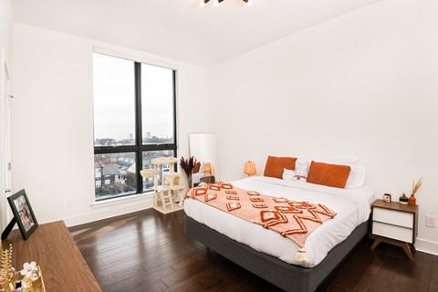 A bedroom with a large bed and a view of the city.