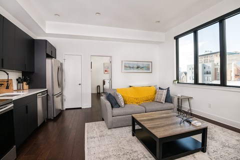 A modern kitchen with a white refrigerator and black cabinets.