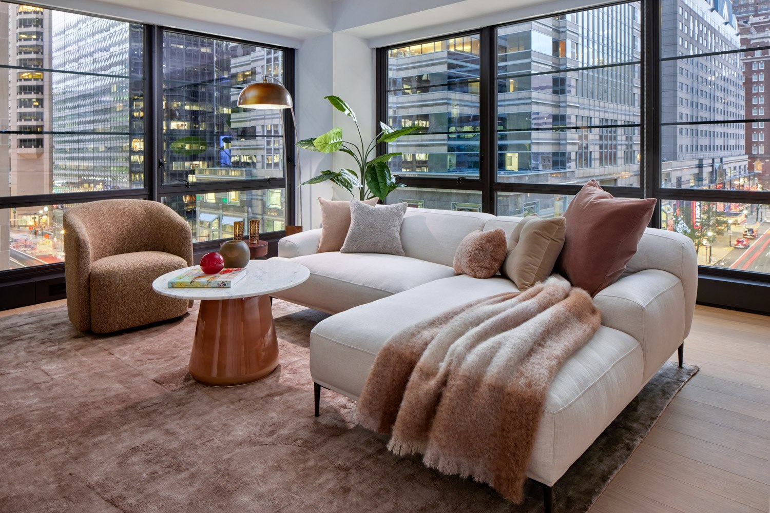 A living room with a white couch and a brown chair.