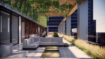 A modern outdoor seating area with a person sitting on a bench.