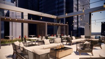 A modern outdoor seating area with white furniture and string lights.