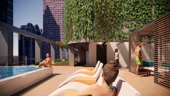 A woman is sitting by a pool on a sunny day.